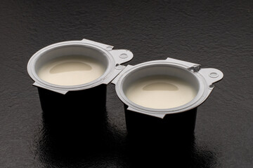 Small milk, coffee creamer pots on red. Mono portions, for catering etc.
Coffee creamer.
Single portion pots of UHT milk for coffee.