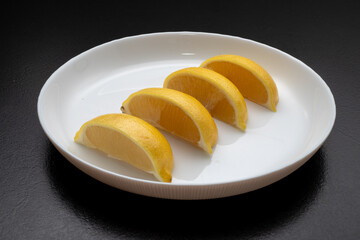 Lemon slices on white plate. Freshness concept, making lemonade with lemon slices. Summer cold...
