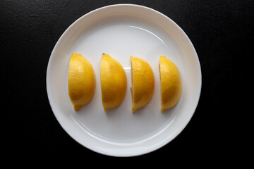 Lemon slices on white plate. Freshness concept, making lemonade with lemon slices. Summer cold...
