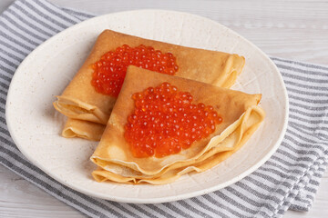 Freshly baked pancakes with red caviar