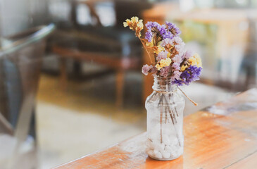 the flower in the bottle on the wooden floor with dramatic tone