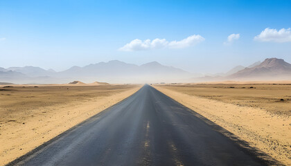 Fototapeta premium asphalt road laid through the desert, going into the distance. in the distance the road is obscured by sand dust. mountains are visible on the horizon