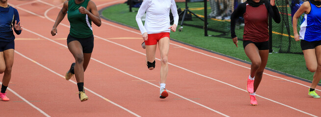 Five High School Girls Sprinting on a Track During a Competitive Race
