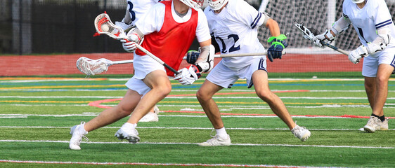 High School Players Engage in Intense Lacrosse Match on a Turf Field