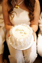 Girl in white holding a cake with an inscription 