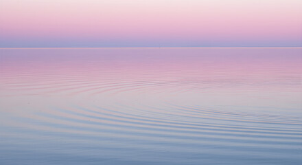 Obraz premium Serene pastel sunset reflecting over the calm, rippled ocean