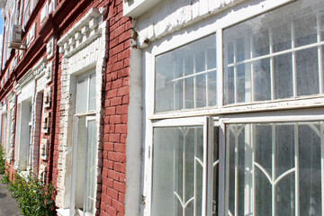 Large windows in an old red brick house are very close.