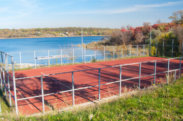 Red Court by the Water: Sport and Nature in Autumn Light