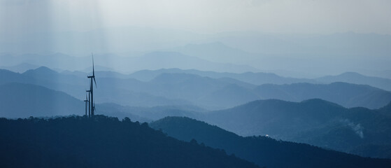 Obraz premium Panoramic view of wind turbines on mountain ridges promoting clean energy and environmental sustainability.