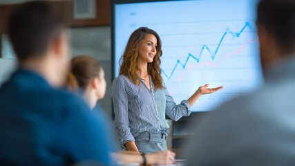 businesswoman giving a presentation on financial growth to colleagues, large screen behind her showing upward trending graphs - Powered by Adobe