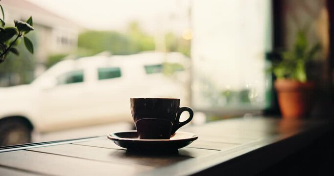 Coffee, empty cafe and cup by window for hospitality, caffeine and espresso in startup. Mug, drink and morning beverage on counter in shop with latte, tea or cappuccino with steam in small business