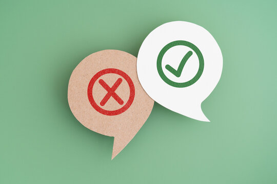 green true and red false mark on real speech bubble paper cut with green background. Concept of positive or negative decision making or choice of approval or rejection