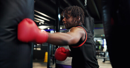 Boxer, man and workout with punching bag in gym for fight training, combat sports and technique....