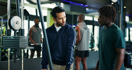 Man, fitness and instructor with client in gym for instructions, tips or demonstration on machine....