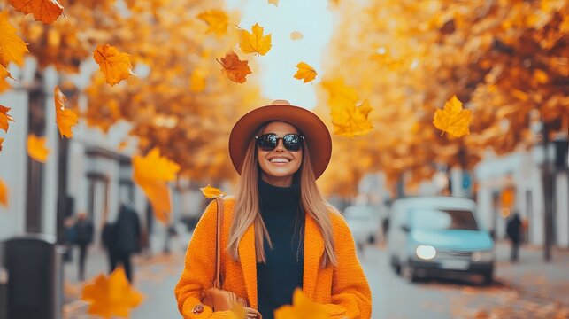 Woman smiles in autumn street with falling leaves wearing hat and coat.