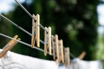 Wooden clothes pegs clipped to a washing line, captured in natural light with a shallow depth of...