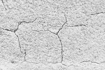 Cracked surface reveals textures of aging concrete in monochrome hues