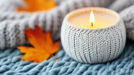 Glowing candlelight casting soft shadows on knitted blanket, scattered autumn leaves creating warm, nostalgic ambiance