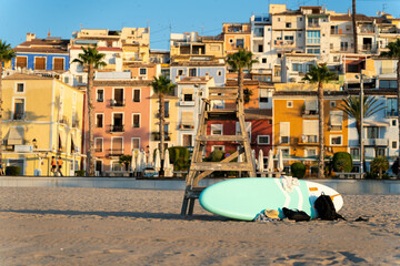 Paddle surf board leaning on a lifeguard chair on villajoyosa beach at sunrise