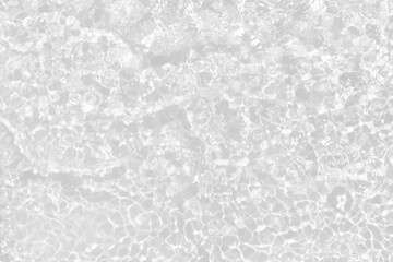 White water with ripples on the surface. Defocus blurred transparent white colored clear calm water surface texture with splashes and bubbles. Water waves with shining pattern texture background.