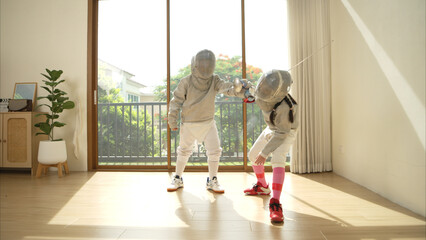 Before the tournament day, a boy and girl dressed in fencing gear are rehearsing in gym