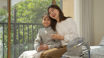 A girl in fencing gear with their mother preparing milk and sports equipment before practicing...