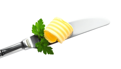 Butter slice on knife with fresh herbs.
