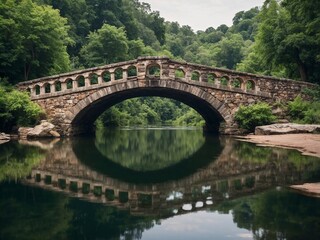 Fototapeta premium Old stone bridge crossing a calm river, lush greenery, reflection in water, daylight