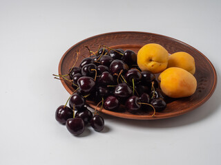 Sweet cherries with apricots isolated on white background cutout. Ripe berries closeup. Mix berries and fruits.