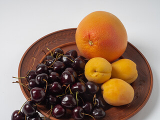 Sweet cherries with apricots isolated on white background cutout. Ripe berries closeup. Mix berries and fruits.