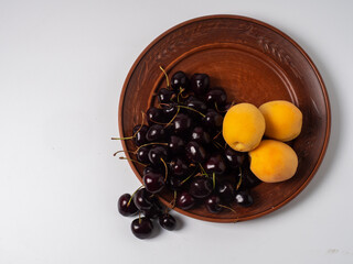 Sweet cherries with apricots isolated on white background cutout. Ripe berries closeup. Mix berries and fruits.