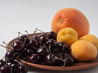 Sweet cherries with apricots isolated on white background cutout. Ripe berries closeup. Mix berries and fruits.
