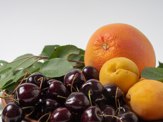 Sweet cherries with apricots isolated on white background cutout. Ripe berries closeup. Mix berries and fruits.