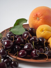 Sweet cherries with apricots isolated on white background cutout. Ripe berries closeup. Mix berries and fruits.