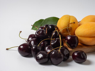 Sweet cherries with apricots isolated on white background cutout. Ripe berries closeup. Mix berries and fruits.