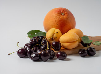 Sweet cherries with apricots isolated on white background cutout. Ripe berries closeup. Mix berries and fruits.
