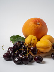 Sweet cherries with apricots isolated on white background cutout. Ripe berries closeup. Mix berries and fruits.