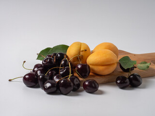 Sweet cherries with apricots isolated on white background cutout. Ripe berries closeup. Mix berries and fruits.