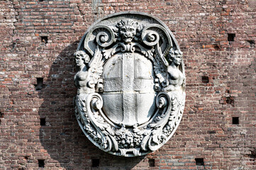 Coat of arms bas-relief on the wall of Sforza castle in Milan, Italy. Ancient restored coat of arms bas-relief on the wall of castle.
