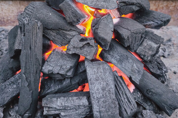 Charcoal fire background for picnic with black coals and vibrant flames