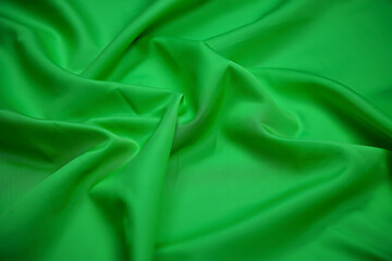 Fototapeta premium Vibrant Green Silk Fabric Drape: Luxurious, Smooth, Elegant Texture Background