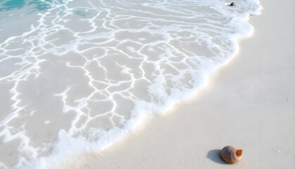 Close-up of a white sandy beach and turquoise waves forming patterns in the sand.