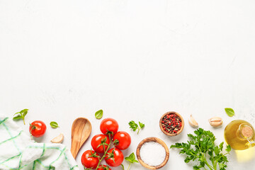 Spices, herbs and vegetables with olive oil on white kitchen table.
