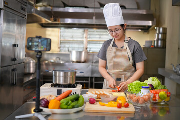 Young woman learning to cook, sandwiches and fresh vegetables placed on the table in a modern...