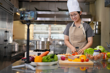 Young woman learning to cook, sandwiches and fresh vegetables placed on the table in a modern...