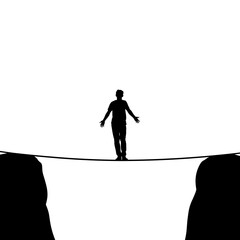 Person balancing on a tightrope between two cliffs in silhouette  