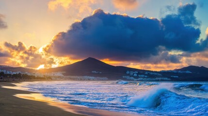 A view of a beach with waves crashing on the sand and a mountain in the background
