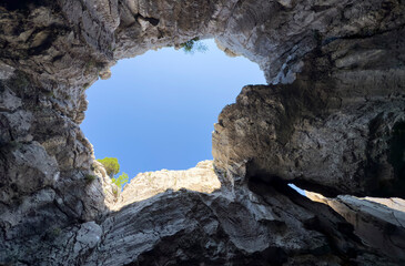 large windows opening onto the sky from cave interiors in wild mountains