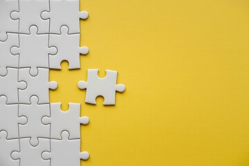 Missing puzzle piece on yellow background problem solving teamwork connection concept with copy space.