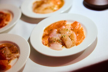 Gourmet Fish Carpaccio with Herbs on White Plate